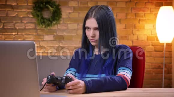 近距离直观地看到年轻的青少年女性视频博主在笔记本电脑上玩电子游戏并失去生气视频的预览图