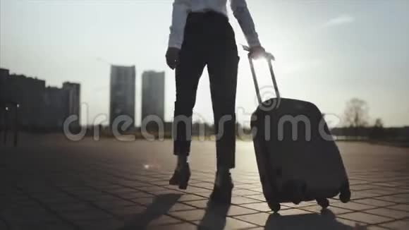 商务女士带着行李从机场去出租车停车场穿高跟鞋的女孩踩着行李箱视频的预览图