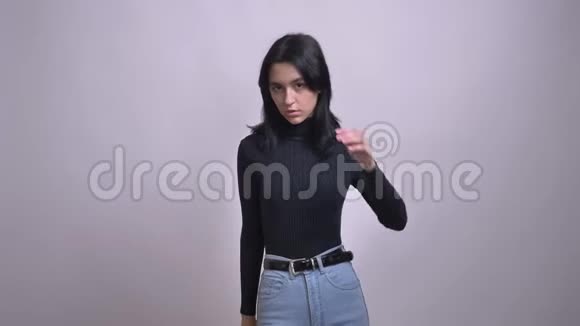 年轻漂亮的白种人黑发女性穿着时尚牛仔裤看着相机和摆姿势的特写镜头视频的预览图