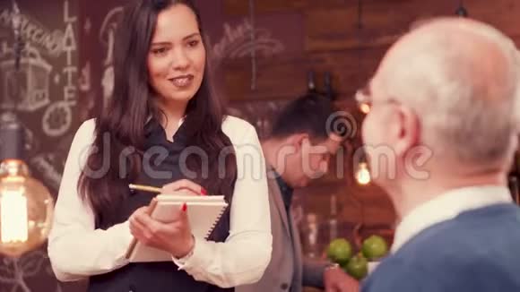 一位漂亮的女服务员从戴眼镜的老人那里点餐视频的预览图
