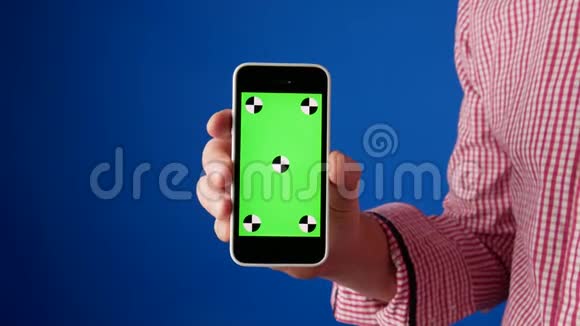 快关门一个穿着红色衬衫的男人的手出现在相机里智能手机上有绿色的色度键并进行刷卡视频的预览图