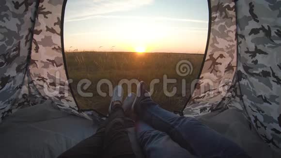 在日落时双腿合拢在帐篷里休息在风景山帐篷露营的快乐夫妇旅行爱情自然和视频的预览图