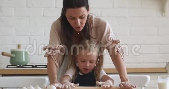 快乐妈妈教可爱的女儿在厨房擀面视频的预览图