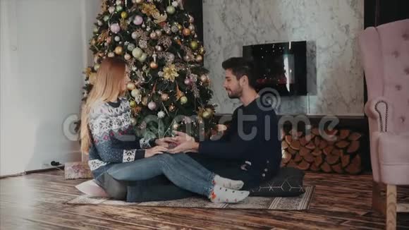 一对夫妇坐在圣诞树的对面聊得很开心视频的预览图
