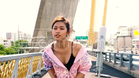 亚洲女运动员在城市桥上跑步视频的预览图