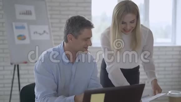 一男一女在现代办公室的笔记本电脑上工作团队合作概念4K视频的预览图