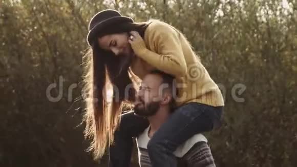夫妇在公园里和黄树玩得很开心秋天的心情显示出彼此的舌头视频的预览图