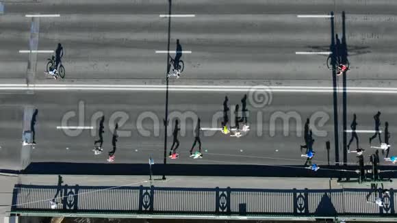 人们跑夏季马拉松在灰色的道路上留下阴影视频的预览图