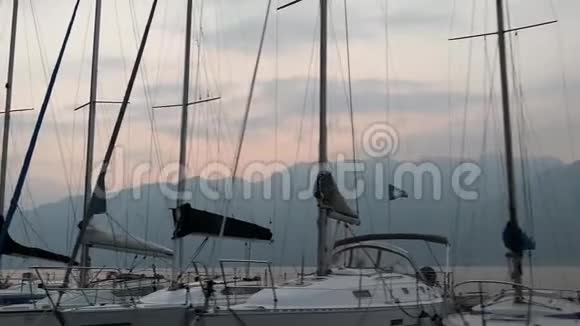 日落时分加德纳湖上一排停泊着的船只从进入港口的船只上拍摄天空多云视频的预览图