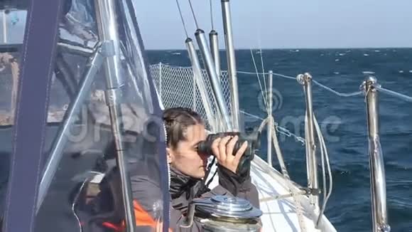 一个女孩在游艇上用望远镜看视频的预览图