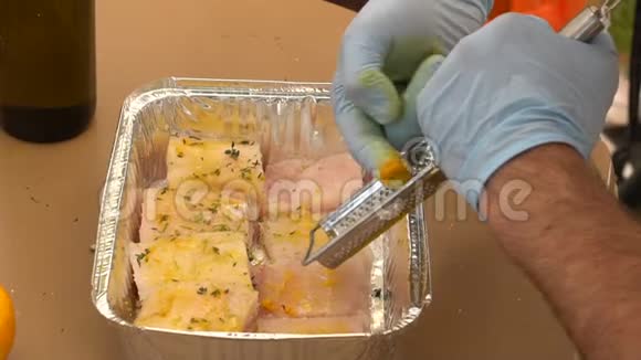 男性的手在鱼片上撒香料在烤箔上慢镜头视频的预览图