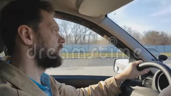城市里阳光明媚的一天一个蓄胡子的人开车视频的预览图
