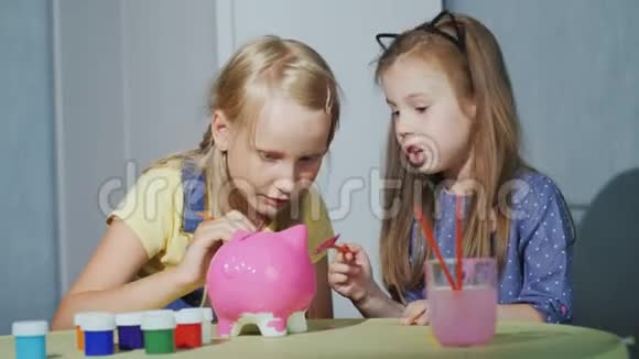 两个小女孩在家一起玩给储蓄罐涂漆视频的预览图
