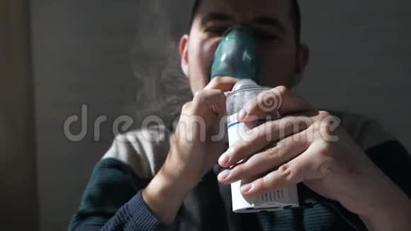 在家拿着吸入器的面具的年轻人通过雾化器治疗气道炎症预防哮喘视频的预览图
