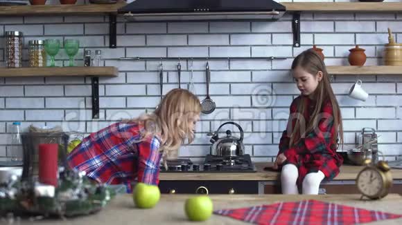 小可爱的女孩坐在厨房的顶部年轻的金发母亲烤饼干把它们从烤箱里拿出来视频的预览图