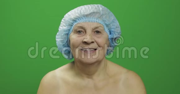 戴防护帽的老年女性医生给她看了一个苹果视频的预览图