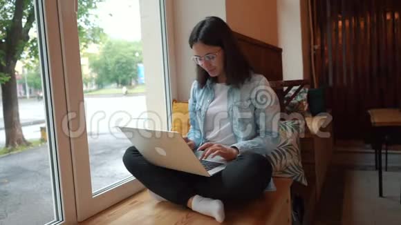漂亮的女人坐在现代咖啡馆里手提上网本年轻迷人的女性自由职业者视频的预览图