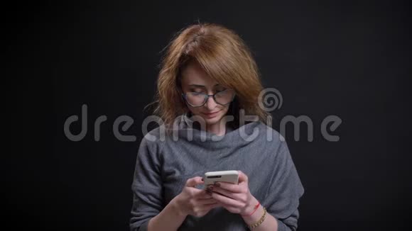 特写照片上有魅力的高加索女性随意在手机上打字背景与黑色隔绝视频的预览图