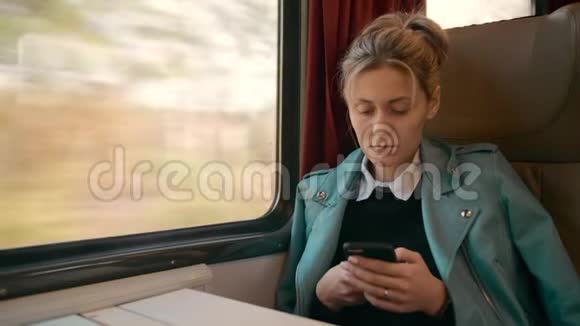 年轻的高加索商务女性正乘坐豪华的城际列车使用手机旅游业务视频的预览图