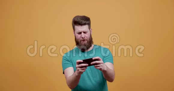 年轻的帅哥在他的智能手机上玩娱乐游戏视频的预览图