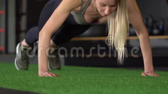 运动美女做俯卧撑作为她的交叉健身健美体操训练常规的一部分慢动作视频的预览图