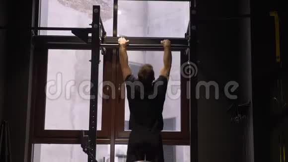 健身馆里的成年肌肉健美运动员在酒吧里举起自己的特写后景拍摄视频的预览图