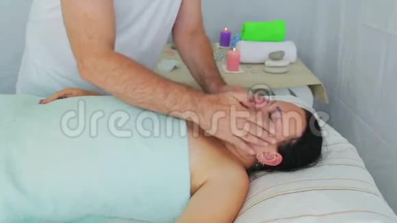 一位男性美容师在一家水疗沙龙里给一位女性客户做面部按摩视频的预览图