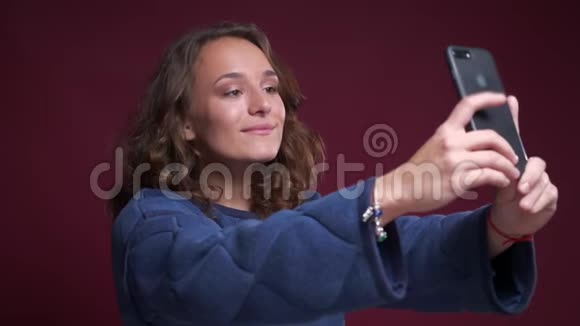 年轻活泼的白种人女性在手机上自拍做出有趣的面部表情和表情视频的预览图