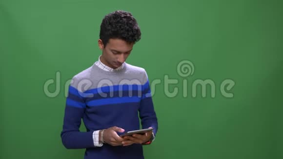 印度年轻男性的特写镜头使用的平板电脑背景与绿色隔离视频的预览图