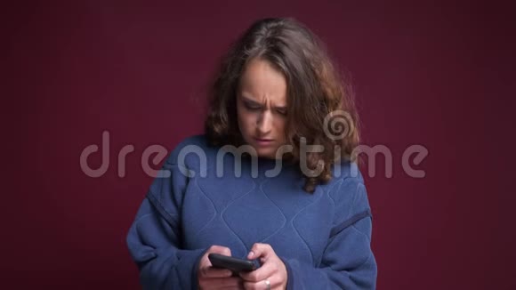 特写照片上年轻迷人的白种人女性在电话里浏览在前面欢快地笑视频的预览图
