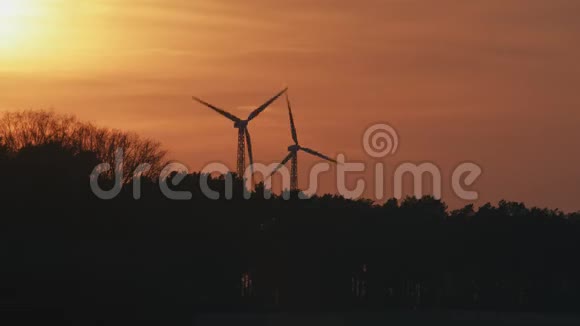 日落时两台风力涡轮机的剪影视频的预览图