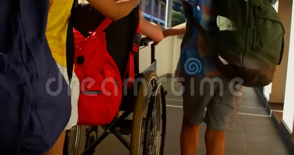 在走廊4k处推着轮椅的残疾女学生视频的预览图