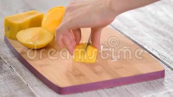 女厨师用手在木砧板上切芒果视频的预览图