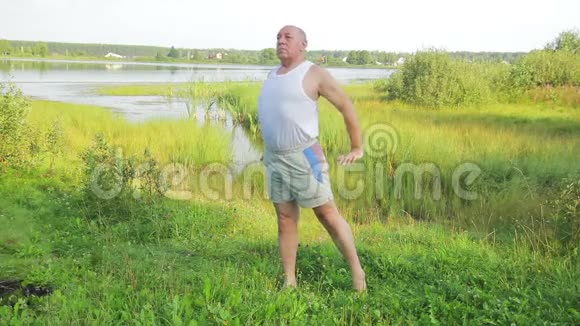 一位中年男子早上在湖边做瑜伽和呼吸练习视频的预览图