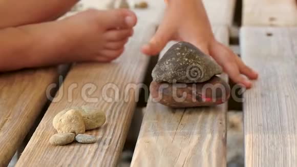 一个孩子正在木架上玩石头特写镜头视频的预览图