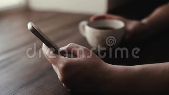 女人正在咖啡馆里喝着一杯咖啡在电话里输入一条信息视频的预览图