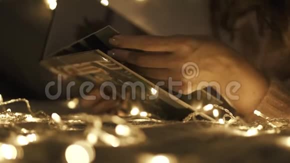 被圣诞灯包围的女人竖起大拇指一本旧照片书圣诞节假期视频的预览图