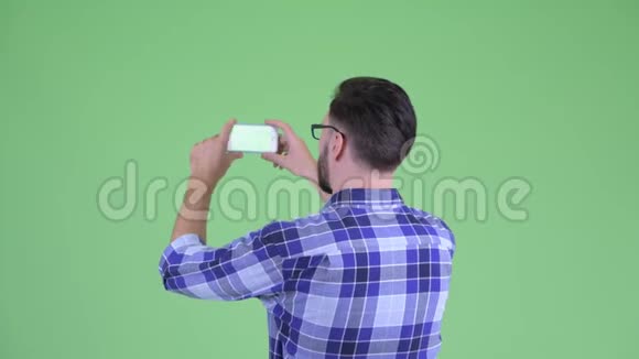 年轻留胡子的时髦男人用电话拍照的后景视频的预览图