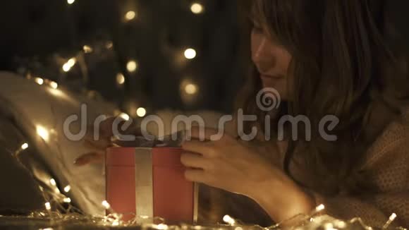 女孩许愿并打开一个圣诞礼物包圣诞节及新年的概念视频的预览图