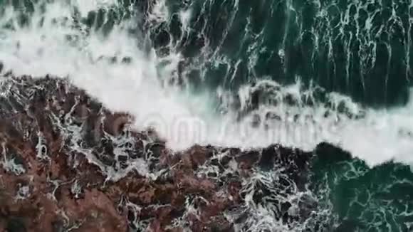 无人驾驶的海景海浪打破石头在风暴中产生泡沫和飞溅视频的预览图