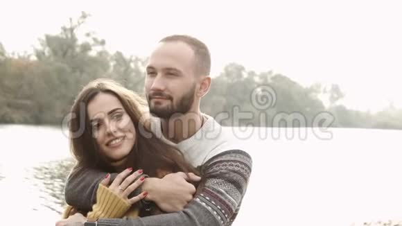 两个人在公园里拥抱背景是河秋天的心情快关门视频的预览图