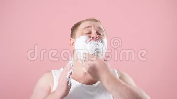 快乐丰满的男人脸上有剃须泡沫剃刀上有粉红色视频的预览图