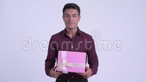 年轻快乐的西班牙商人一边拿着礼品盒一边思考视频的预览图