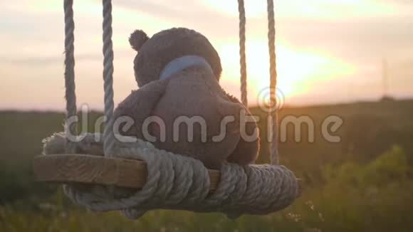 日落时泰迪熊坐在绳子上摆动关于孤独的概念视频的预览图