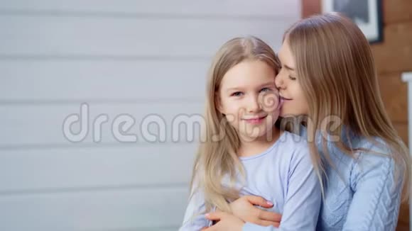 中度特写快乐的年轻母亲亲吻享受美好时光可爱的小女儿视频的预览图