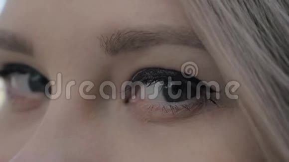 一位美丽的金发欧洲女人睁开灰色眼睛的特写镜头视频的预览图