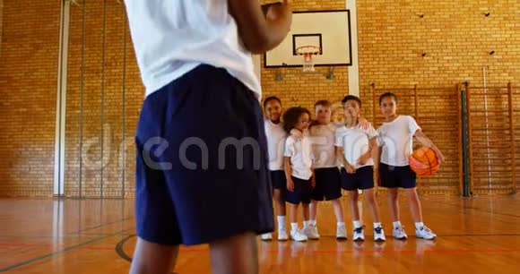 学生用手机点击照片他的朋友在学校篮球场4k视频的预览图