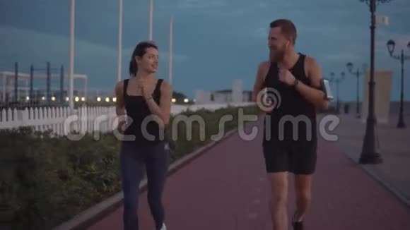 男人和女人慢跑者晚上在户外跑步时调情快乐的面孔视频的预览图