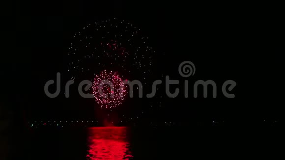 夜空中明亮的节日烟火映在水面上视频的预览图