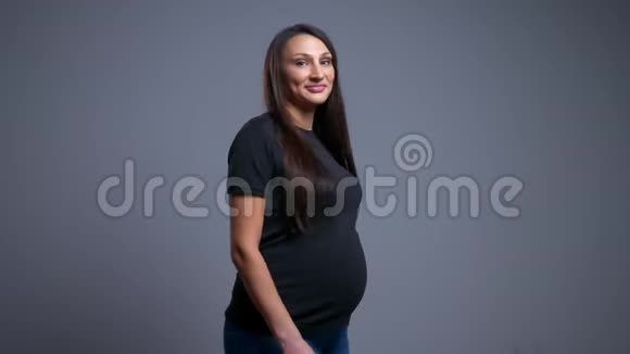 怀胎开朗的白种人女性转身看着镜头微笑的特写镜头视频的预览图